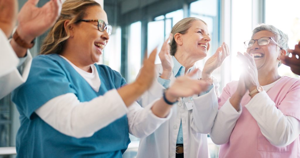 A group of health care workers clapping