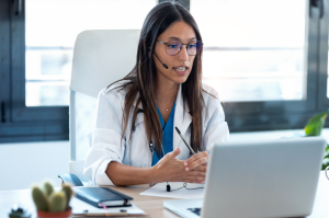 A doctor speaking into a computer screen