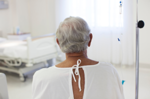 An older patient sitting in a hospital room